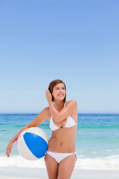 Roztomilá žena s její míč na pláži — Stock fotografie