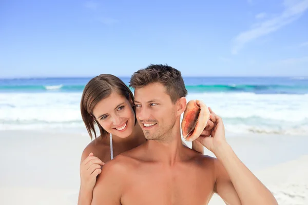 Lovers listening to their shell — Stock Photo, Image