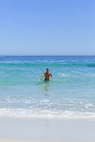 人和他的冲浪板在沙滩上跑 — 图库照片