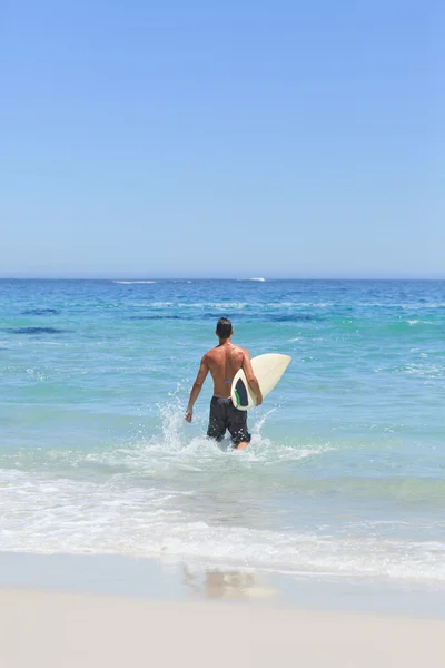 Uomo che corre sulla spiaggia con la tavola da surf — Foto Stock
