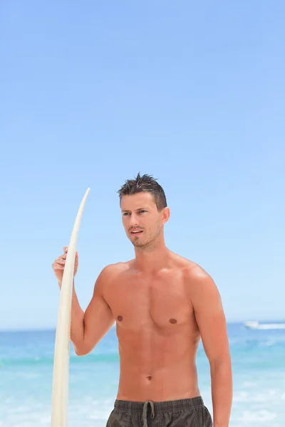 Homem posando com sua prancha de surf — Fotografia de Stock