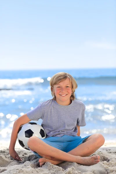 Хлопчик з м'ячем на пляжі — стокове фото