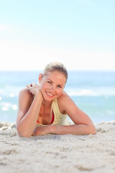 Een vrouw zonnebaden op het strand — Stockfoto