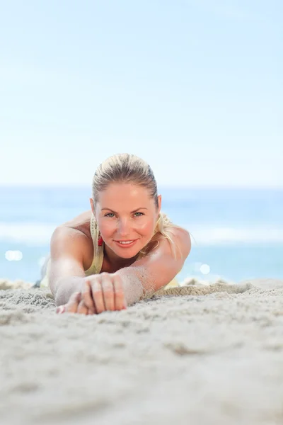 Een vrouw zonnebaden op het strand — Stockfoto