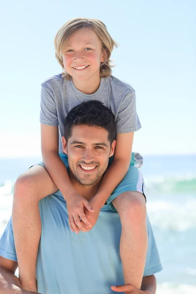 Ο πατέρας έχει γιο μια piggyback στην παραλία — Φωτογραφία Αρχείου