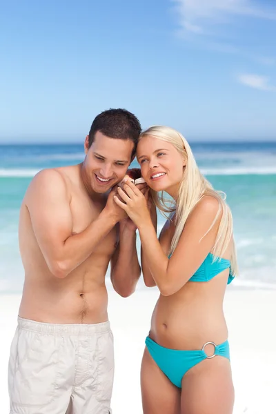 Couple listening to their shell — Stock Photo, Image