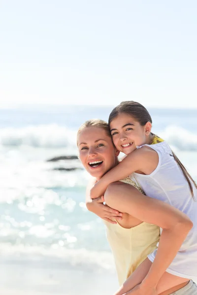 Μητέρα έχει την κόρη ενός piggyback στην παραλία — Φωτογραφία Αρχείου