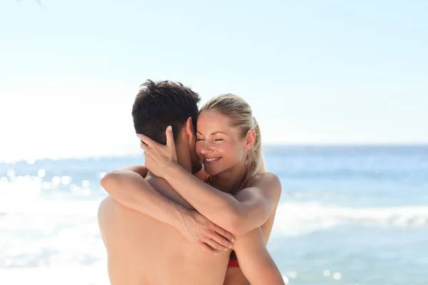 Woman hugging her boyfriend at the beach — Stock Photo, Image