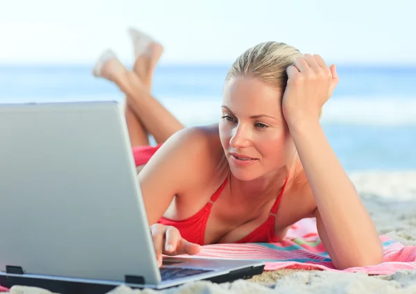 Bella donna che lavora sul suo computer portatile in spiaggia — Foto Stock