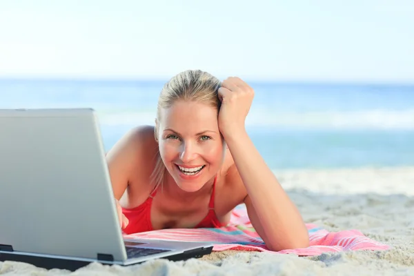 Kumsalda dizüstü bilgisayarıyla çalışan hoş bir kadın. — Stok fotoğraf