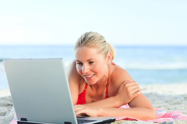 Piękna kobieta pracuje nad laptopem na plaży — Zdjęcie stockowe