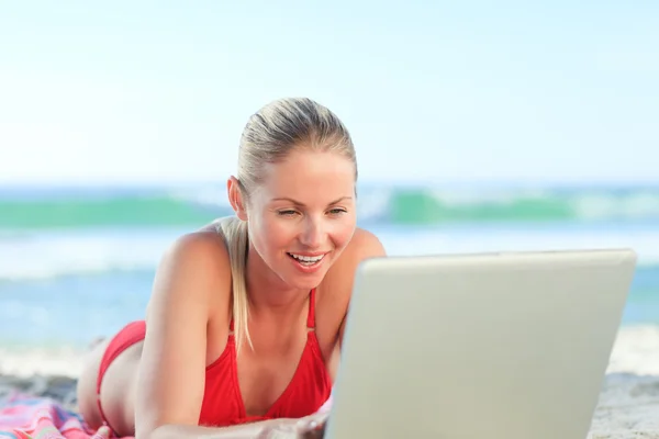 Lovely woman working on her laptop at the beach — Stock Photo, Image