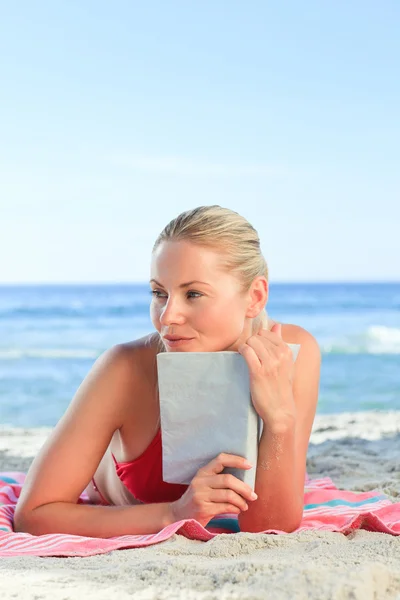 Urocza kobieta czytająca książkę na plaży — Zdjęcie stockowe