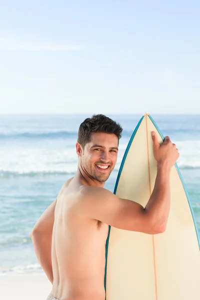 अपने सर्फबोर्ड के साथ समुद्र के पास सुंदर आदमी — स्टॉक फ़ोटो, इमेज