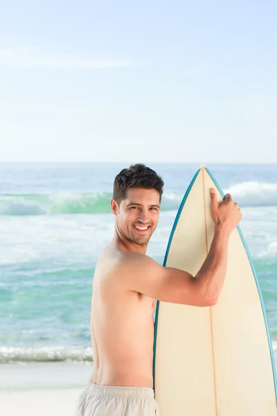 在与他的冲浪板海旁边的英俊男子 — 图库照片