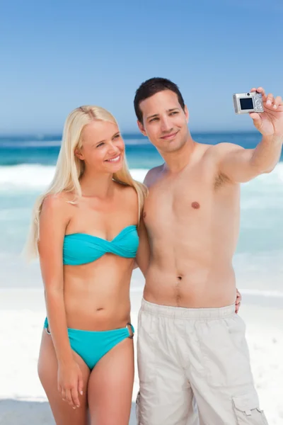 Ζευγάρι που αναλαμβάνει μια φωτογραφία του εαυτού τους, στην παραλία — Φωτογραφία Αρχείου