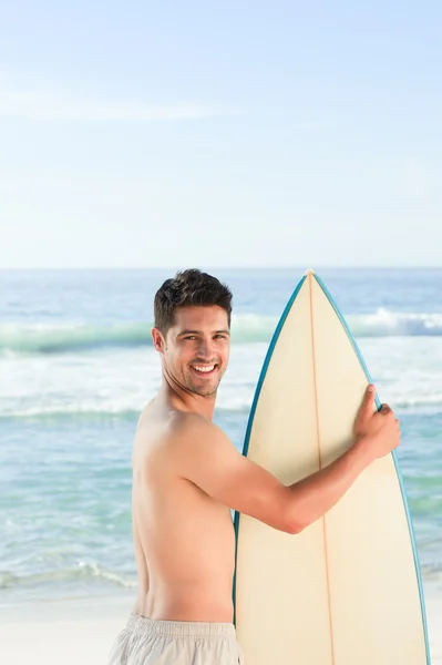 Przystojny mężczyzna obok morza z jego deskę surfingową — Zdjęcie stockowe