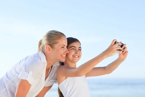 Little girl taking a photo of herself and her mother — Stock Photo, Image