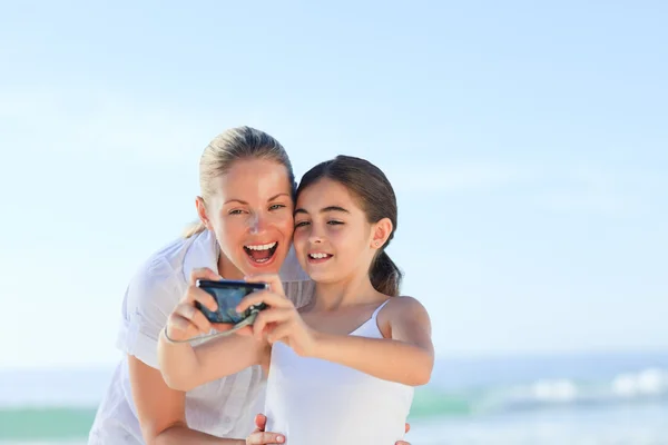 Menina tirando uma foto de si mesma e sua mãe — Fotografia de Stock