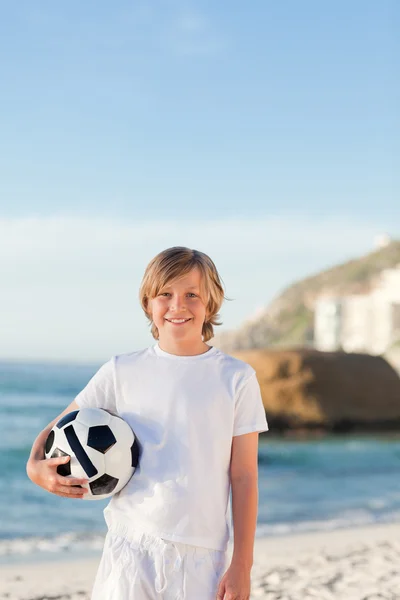 Liten pojke med sin boll på stranden — Stockfoto