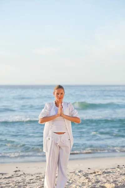Frau praktiziert Yoga am Strand — Stockfoto