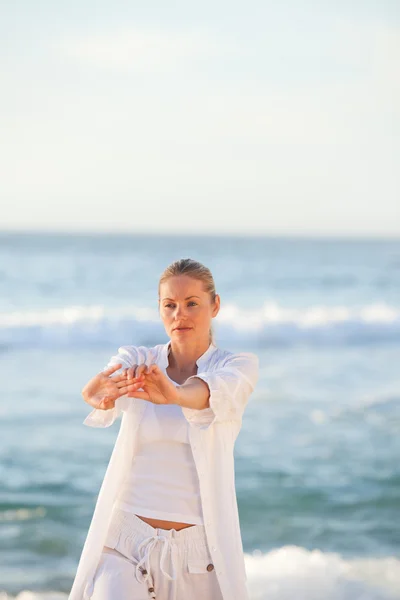 Mulher praticando ioga na praia — Fotografia de Stock