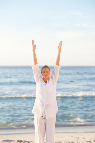 Vrouw het beoefenen van yoga op het strand — Stockfoto