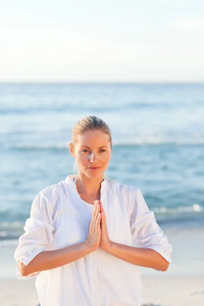Woman practicing yoga at the beach — Stock Photo, Image