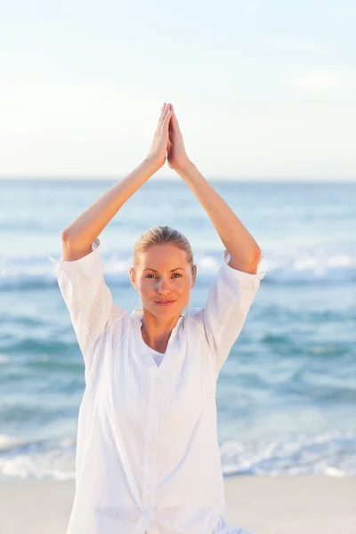 Mujer activa practicando yoga en la playa —  Fotos de Stock
