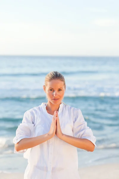 Femme active pratiquant le yoga sur la plage — Photo