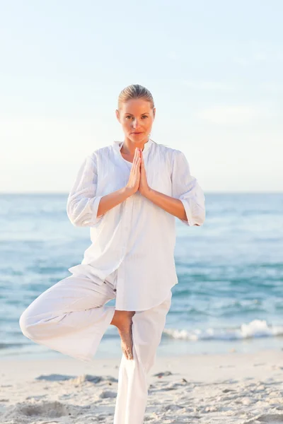 Mujer activa practicando yoga en la playa —  Fotos de Stock