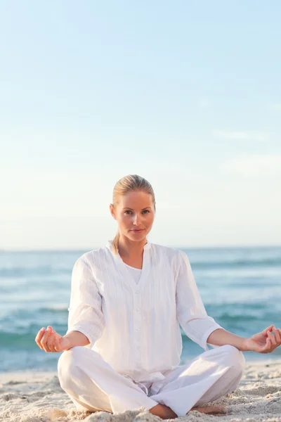 Mulher ativa praticando ioga na praia — Fotografia de Stock