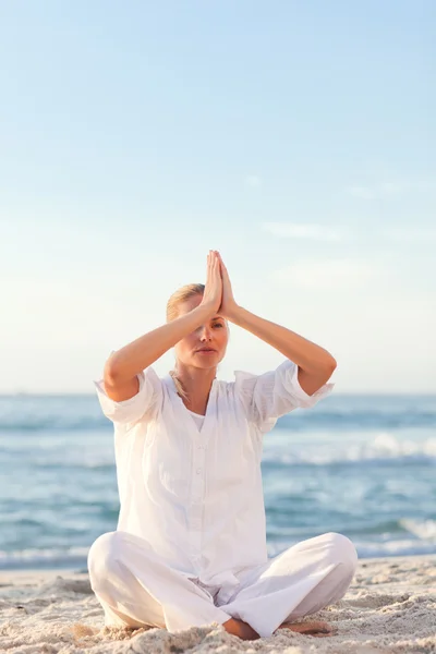 Aktiv kvinna utövar yoga på stranden — Stockfoto