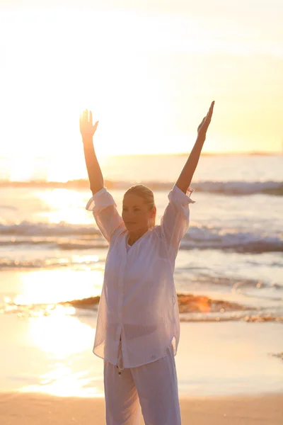 Frau praktiziert Yoga während des Sonnenuntergangs — Stockfoto