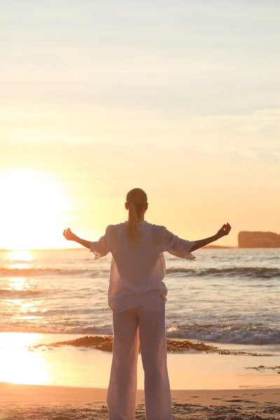 Femme pratiquant le yoga pendant le coucher du soleil — Photo