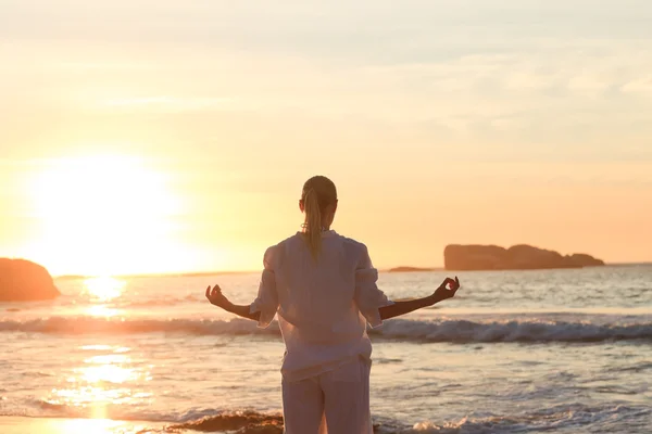 Woman practicing yoga during the sunset — Stock Photo, Image