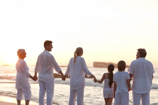 Família na praia durante o pôr do sol — Fotografia de Stock