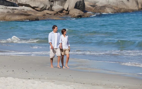 Пара прогулок по пляжу под солнцем — стоковое фото