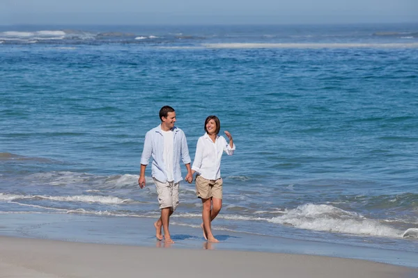 Пара прогулок по пляжу под солнцем — стоковое фото
