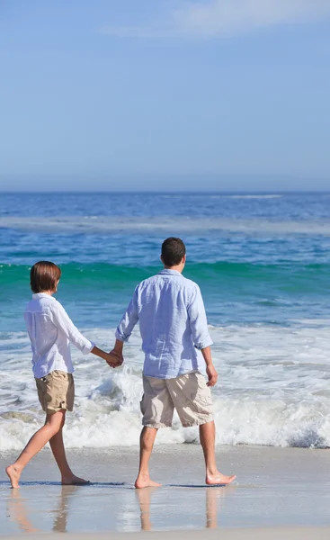 在阳光下的沙滩上散步的情侣 — 图库照片