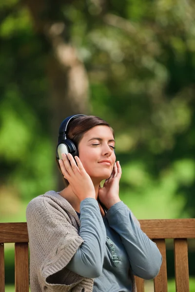 Mujer joven escuchando algo de música —  Fotos de Stock