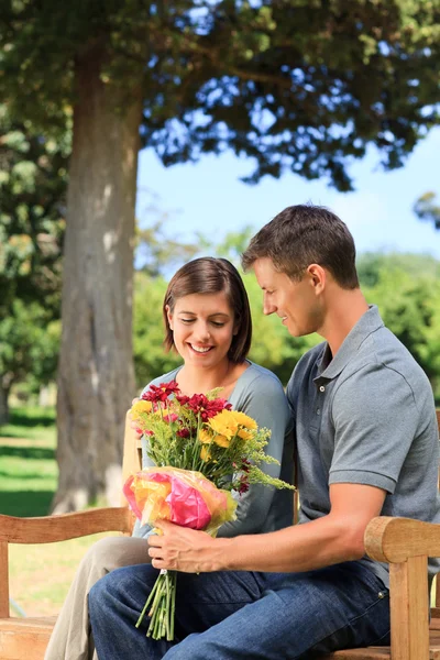 Ember kínál virágok, hogy a barátnője — Stock Fotó