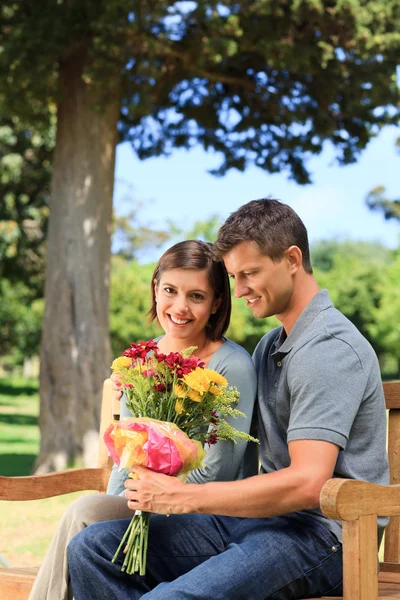 Człowiek oferuje kwiaty do jego dziewczyna — Zdjęcie stockowe