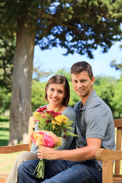 Junger Mann bietet seiner Freundin Blumen an — Stockfoto