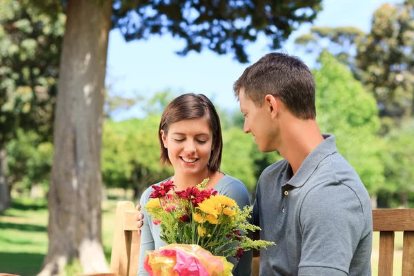 젊은 남자가 그의 여자 친구에 게 꽃을 제공 — 스톡 사진