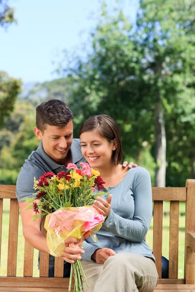 Young man offering flowers to his girlfriend — Stock Photo, Image