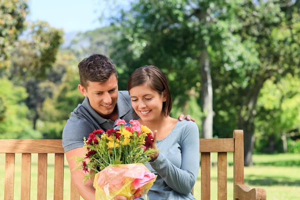 Joven hombre ofreciendo flores a su novia — Foto de Stock