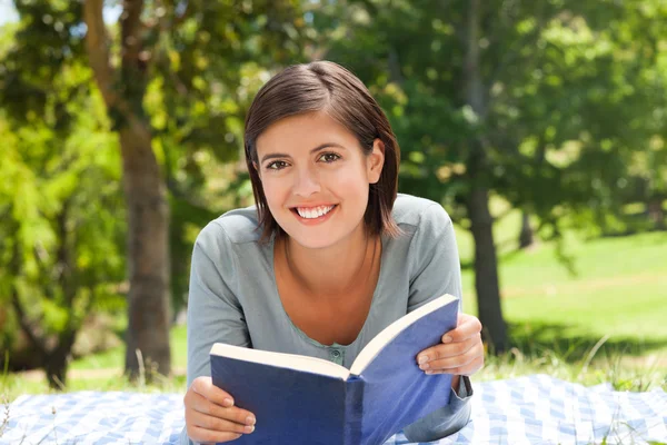 Egy nő könyvet olvas a parkban. — Stock Fotó