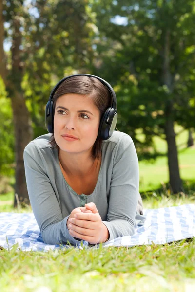听一些音乐在公园里的女人 — 图库照片