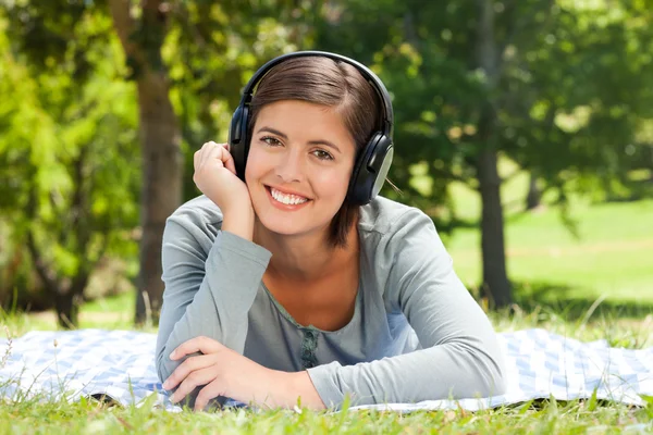 Donna che ascolta della musica nel parco — Foto Stock
